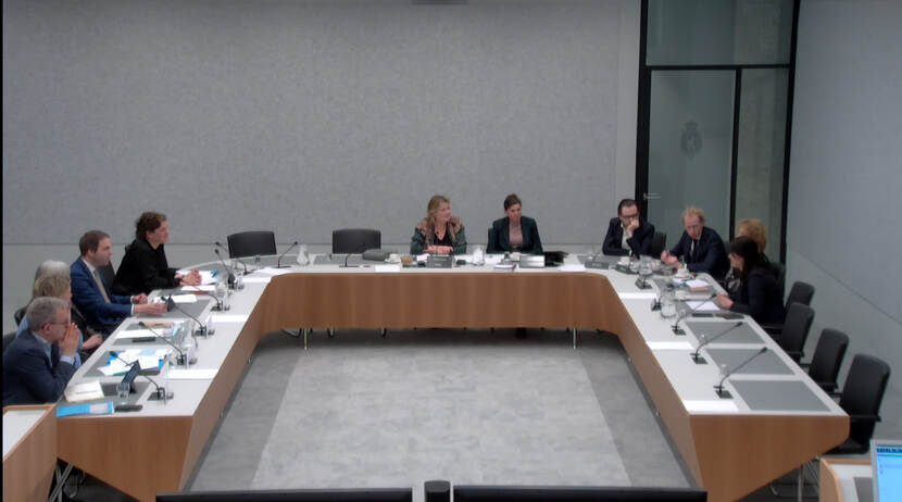 Elf personen aan een vergadertafel in de Tweede Kamer